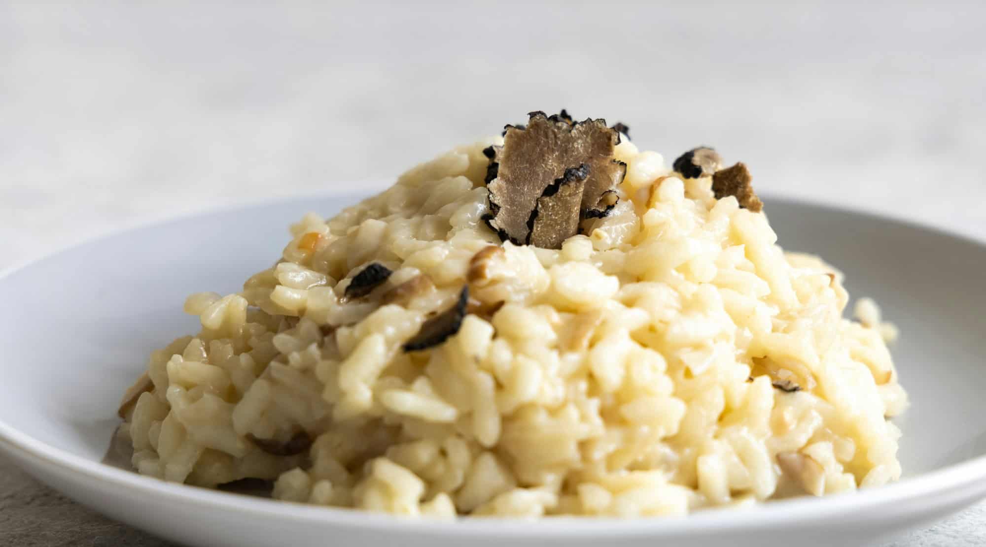 Risotto aux cèpes et truffes noires servi dans une assiette vue du dessus, cousine gourmande