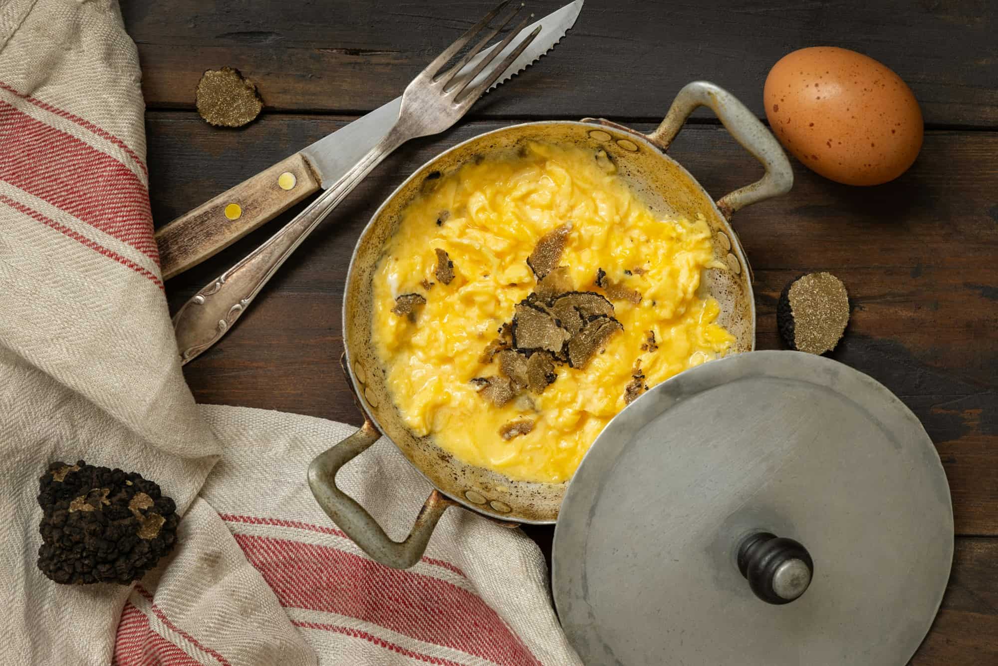 Œufs brouillés aux truffes noires fraîches d'Italie servis dans une poêle, petit-déjeuner gourmet
